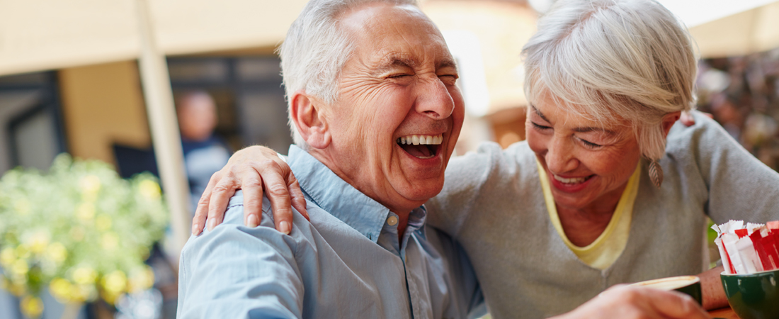 photo of senior couple sharing a laugh at a coffee shop