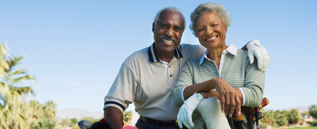 photo of smiling senior couple with their golf clubs