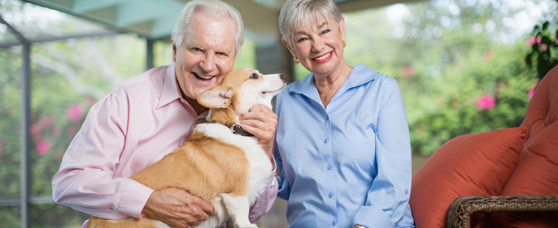 photo of smiling senior couple with their corgie dog